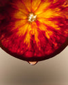 Close-up of a sliced blood orange with vibrant red and yellow interior.